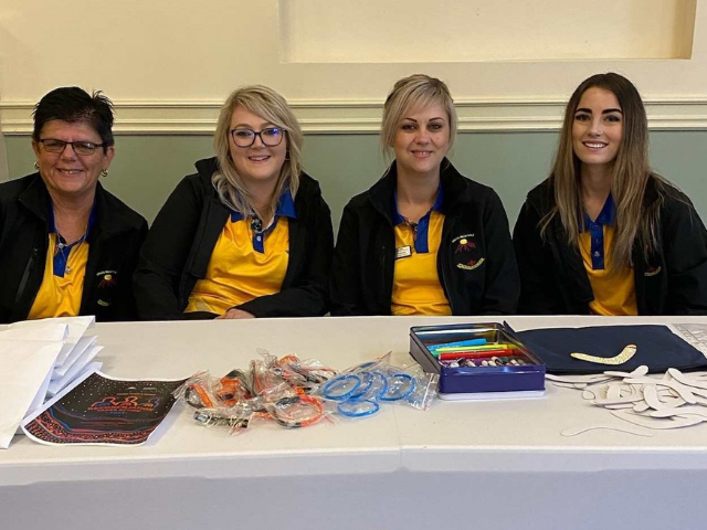 Binaal Billa Family Violence Prevention Legal Service staff Debbie Stevie, Jade and Taylor sitting at a table together.